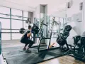 Mężczyzna wykonuje przysiad ze sztangą. Trening siłowy to świetny sposób na spalanie kalorii.