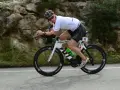 Zawodnik na rowerze triathlonowym pokonuje długi Ironman dystans, pędząc po górskiej trasie.