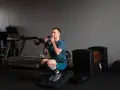 Mężczyzna wykonuje głęboki **squat** z kettlebell w rękach, ćwicząc siłę w siłowni.