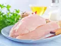 Surowe filety z kurczaka na talerzu, gotowe do przygotowania. W tle olej, sól i natka pietruszki. Idealne dla dbających o filet z kurczaka kcal.