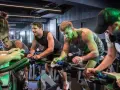 Intensywny trening spinningowy w grupie. Ludzie z determinacją kręcą pedałami, każdy w swoim rytmie.
