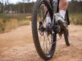 Noga rowerzysty na pedale, jazda po piaszczystej ścieżce. Świetny sposób, jak poprawić kondycję.