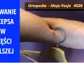 Zerwanie bicepsa w części dalszej. Widoczny hak wbit w mięsień, symbolizujący uraz.
