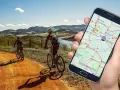 Rowerzyści na malowniczej trasie, a w dłoni smartfon z mapą - idealna aplikacja na rower do odkrywania nowych szlaków.