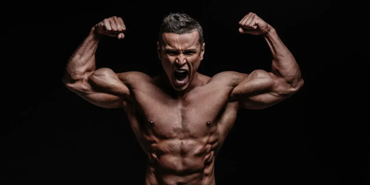 Mężczyzna z wyrzeźbionymi mięśniami napina bicepsy, krzycząc z wysiłku. Jego sylwetka sugeruje intensywny trening, być może z użyciem clenbuterolu.