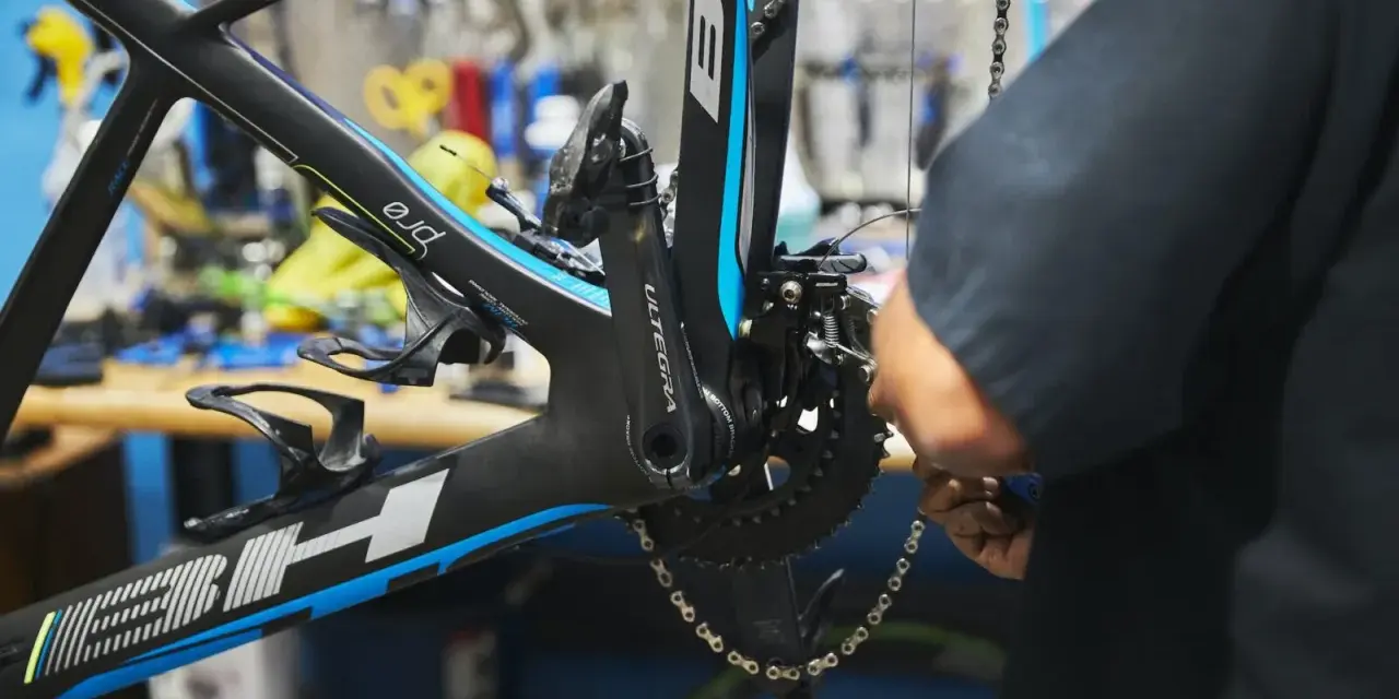Mechanik dokonuje regulacji przedniej przerzutki w rowerze szosowym BH.