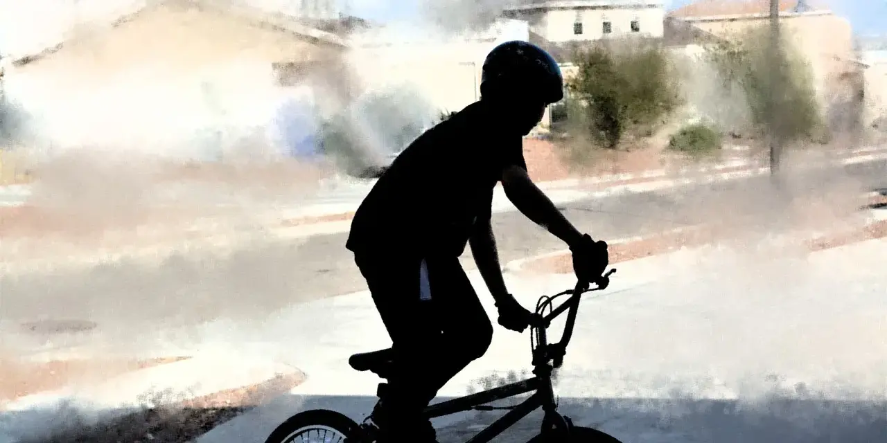Chłopiec w kasku na rowerze BMX, gotowy na trening. Idealny posiłek przedtreningowy to energia do jazdy!
