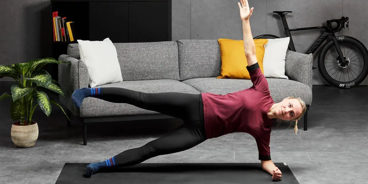 Kobieta wykonuje ćwiczenia oporowe w pozycji bocznej deski na macie w salonie.
