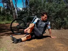 Kolarz wykonuje ćwiczenie rozciągające po jeździe. To jedno z 10 ćwiczeń rozciągających, które pomogą Ci odzyskać siły.