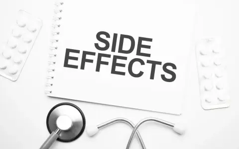 Notatka z napisem "SIDE EFFECTS" obok stetoskopu i opakowań leków. Czy NAC suplement ma skutki uboczne?