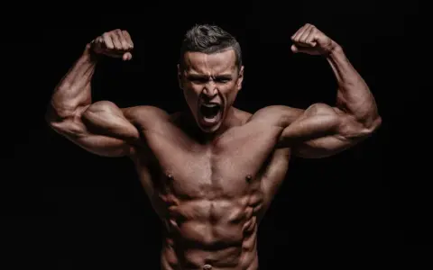 Mężczyzna z wyrzeźbionymi mięśniami napina bicepsy, krzycząc z wysiłku. Jego sylwetka sugeruje intensywny trening, być może z użyciem clenbuterolu.