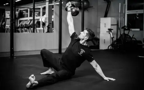 Mężczyzna wykonuje ćwiczenia na siłowni z kettlebell.