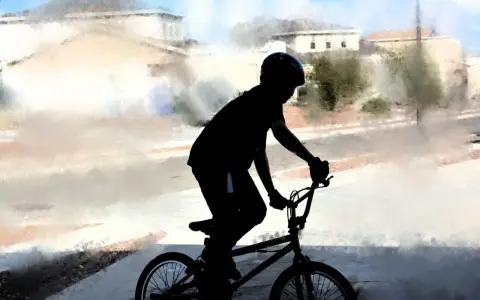 Chłopiec w kasku na rowerze BMX, gotowy na trening. Idealny posiłek przedtreningowy to energia do jazdy!