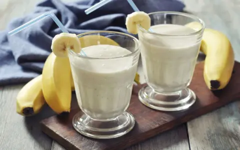 Dwa pyszne szejki proteinowe z bananem, gotowe do wypicia. Idealne po treningu!