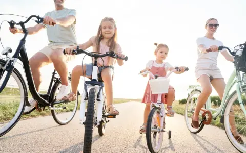 Rodzina na rowerach. Czy karta rowerowa jest obowiązkowa? Dzieci i rodzice cieszą się wspólną przejażdżką.