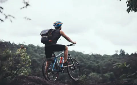 Rowerzysta z plecakiem na tle górskiego krajobrazu. Czy to będzie gravel, czy szosa, przygoda czeka!