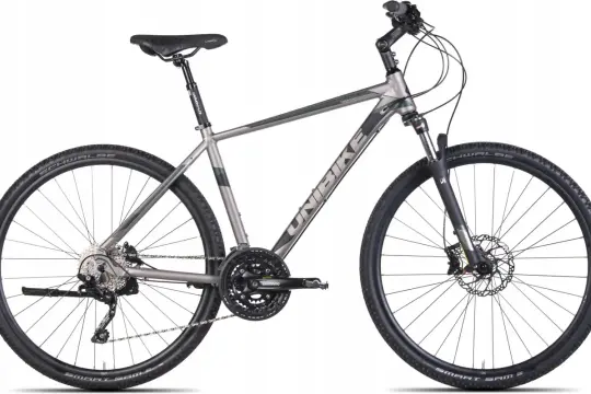 Szary rower trekkingowy Unibike z napędem Shimano i oponami Schwalbe Smart Sam. Wiele pozytywnych unibike opinie potwierdza jego wszechstronność.