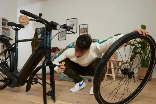 Mężczyzna przy rowerze, wykonuje znakowanie rowerów.