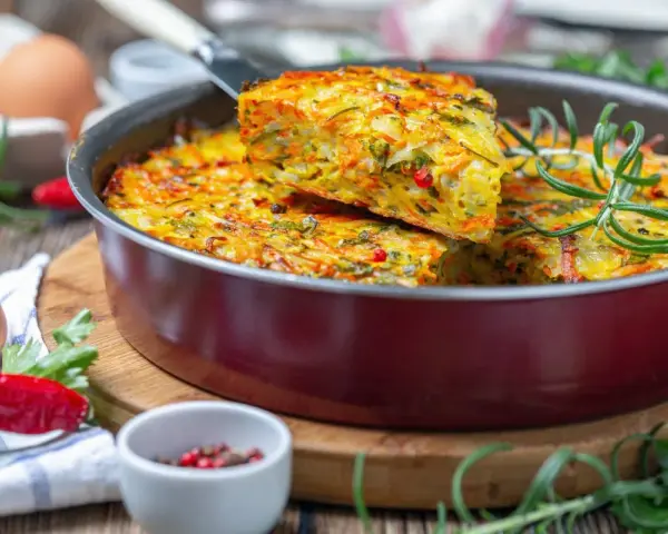 Pyszna keto kolacja w formie zapiekanki z warzywami i ziołami, podana w patelni.