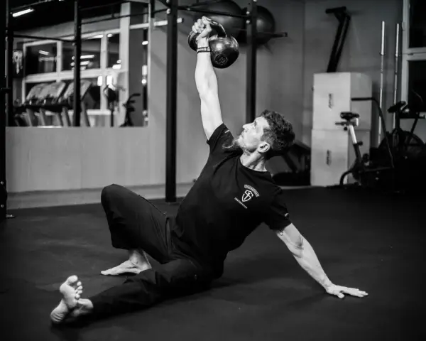Mężczyzna wykonuje ćwiczenia na siłowni z kettlebell.