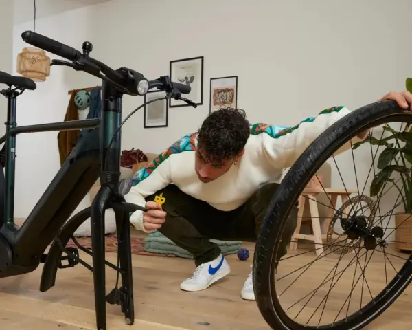 Mężczyzna przy rowerze, wykonuje znakowanie rowerów.