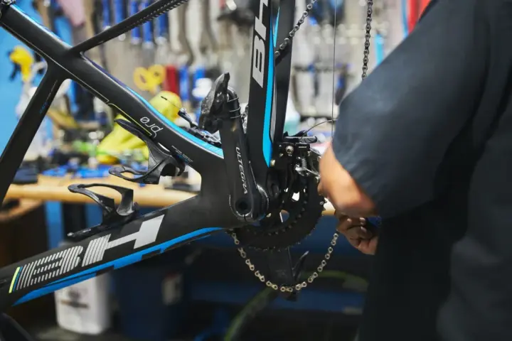 Mechanik dokonuje regulacji przedniej przerzutki w rowerze szosowym BH.