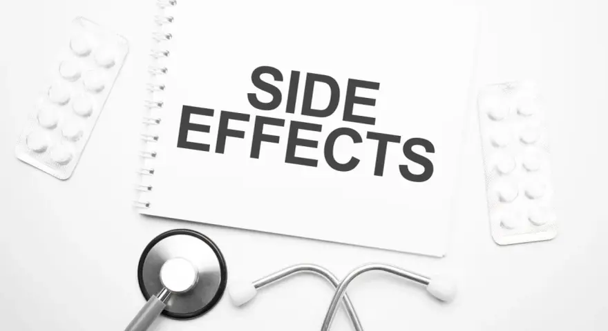 Notatka z napisem "SIDE EFFECTS" obok stetoskopu i opakowań leków. Czy NAC suplement ma skutki uboczne?