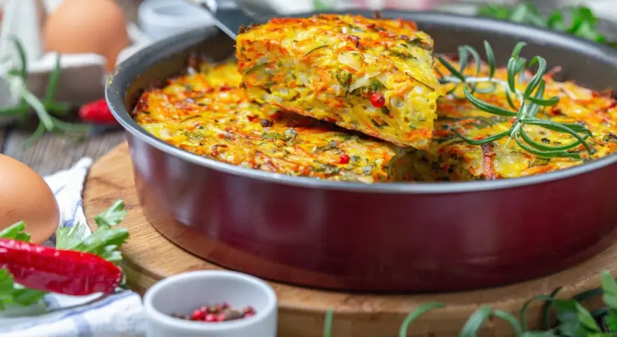 Pyszna keto kolacja w formie zapiekanki z warzywami i ziołami, podana w patelni.