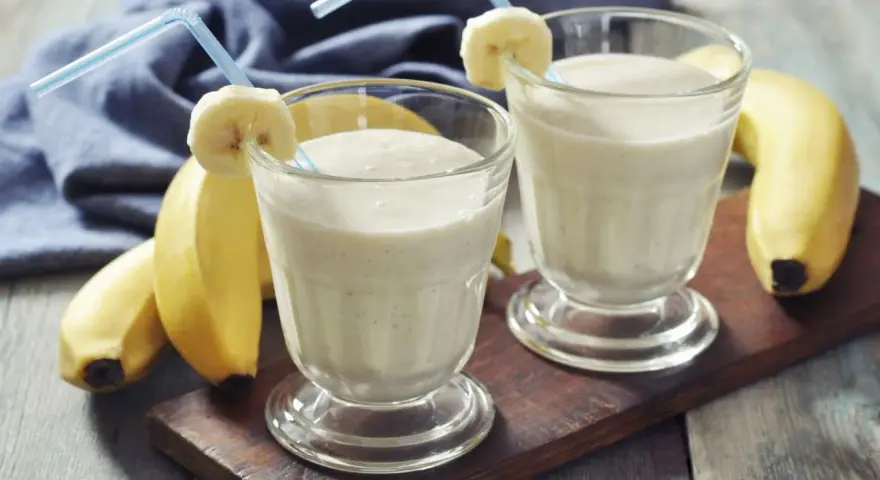Dwa pyszne szejki proteinowe z bananem, gotowe do wypicia. Idealne po treningu!
