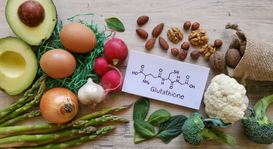 Glutation na co pomaga? Zdrowa żywność: awokado, jajka, warzywa, orzechy i wzór chemiczny glutationu.