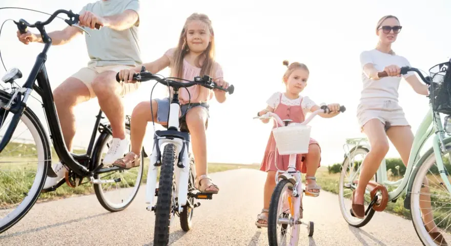 Rodzina na rowerach. Czy karta rowerowa jest obowiązkowa? Dzieci i rodzice cieszą się wspólną przejażdżką.