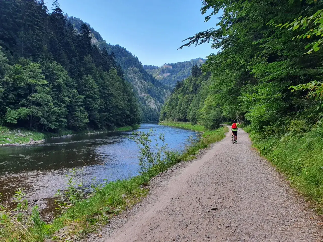 Rowerzystka na trasie Velo Dunajec, wśród zielonych gór i szumiącej rzeki.