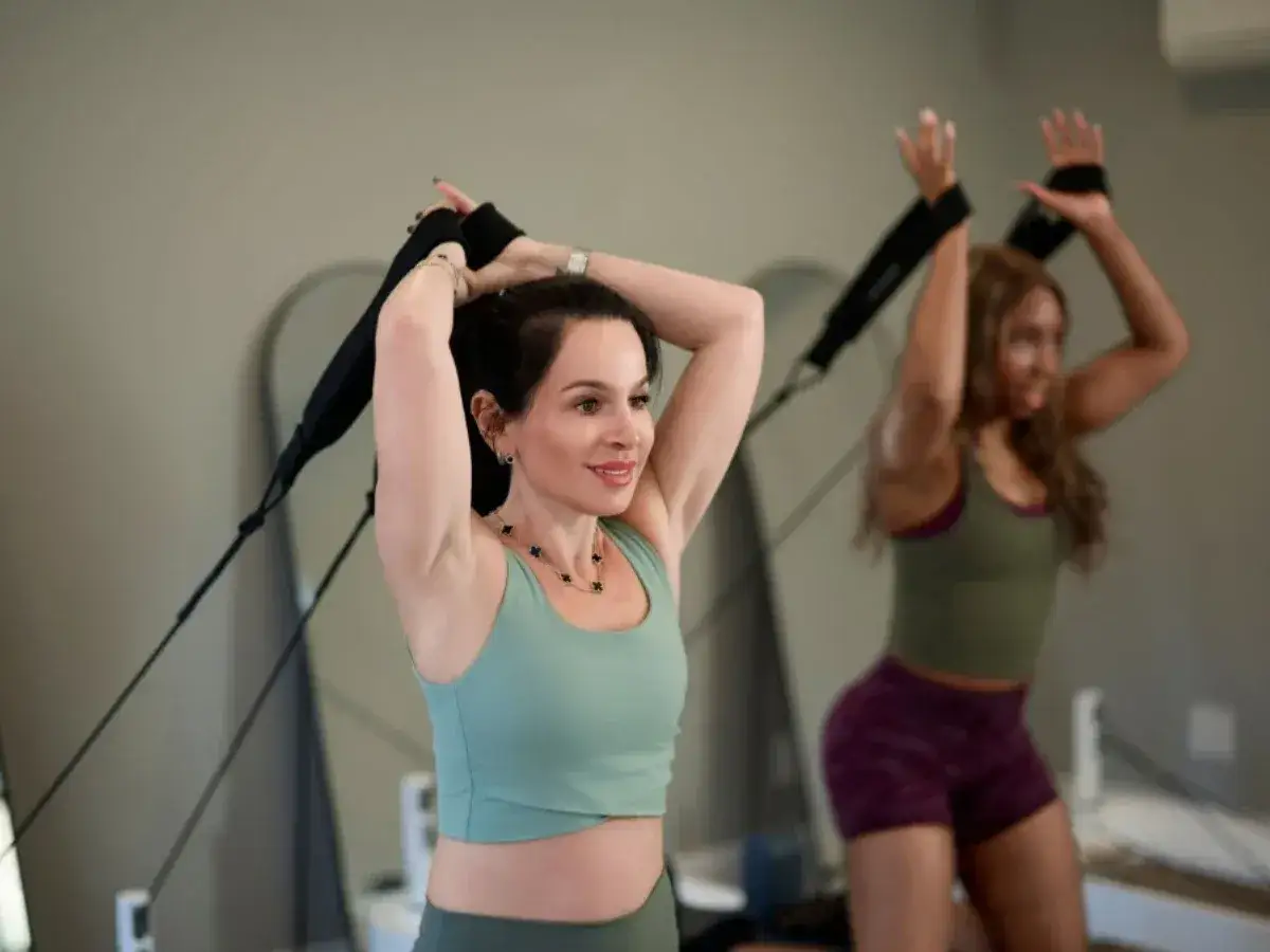 Dwie kobiety ćwiczą pilates, wzmacniając ciało i umysł. Widzisz, co daje pilates: siłę, elastyczność i spokój.