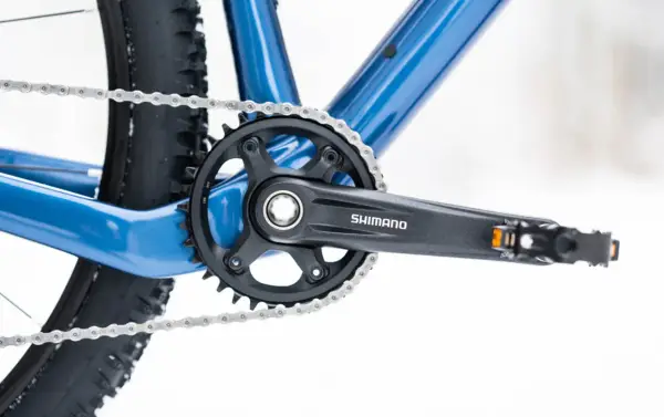 Jak odkręcić pedały w rowerze? Widok na korbę Shimano, łańcuch i fragment ramy roweru.